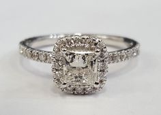 an engagement ring with a cushion cut diamond surrounded by pave diamonds