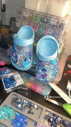 there are many crafting supplies on the table and one has blue shoes with sequins