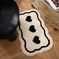 a black and white rug on the floor next to a chair