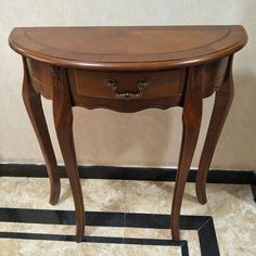 a small wooden table sitting on top of a tiled floor