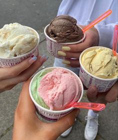 three people holding ice creams in their hands