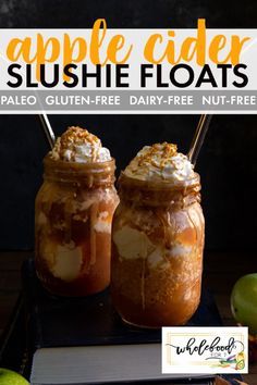 two jars filled with apple cider slushie floats on top of a table