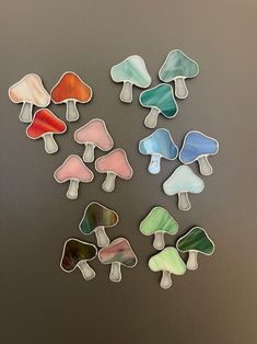 six different colored glass mushrooms sitting on top of a table