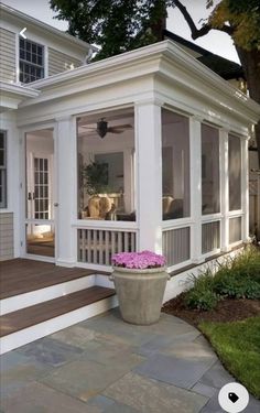 a white house with large windows and steps leading up to the front door