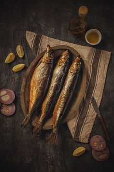 three fish are sitting on a plate next to onion slices