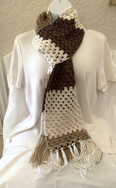 a crocheted scarf hanging on a mannequin