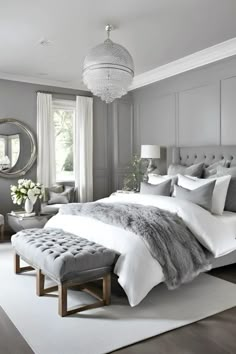 a bedroom with gray walls, white bedding and a bench in front of the bed