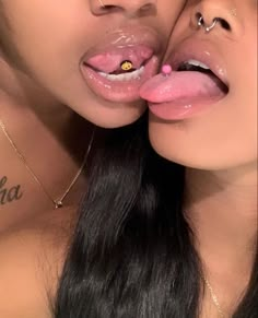 two young women with piercings on their lips are posing for the camera and one is sticking her tongue out