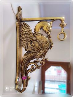 an ornately decorated gold hook hangs on the wall