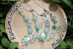 some green and white glass beads on a wooden board with leaves in the foreground