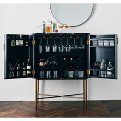 a black cabinet filled with lots of bottles and glasses