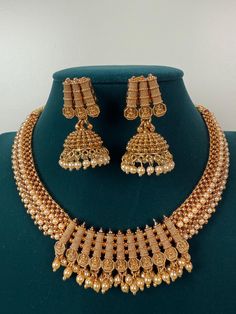 This exquisite piece of craftsmanship comes from our Traditional collection. Finish: 24 grams gold finish Necklace Fastening: Adjustable Dori  Perfect for Indian weddings. Earring jhumka Fastening: Push Back Contains: 1 necklace, 1 pair of earrings Luxury Gold Temple Necklace With Peacock Design, Luxury Temple Necklace With Peacock Design For Festivals, Gold Chandbali Necklace With Latkans, Gold Chandbali Necklaces For Wedding, Gold Tilla Necklace For Wedding, Gold Chandbali Necklace For Wedding, Gold Necklace For Wedding And Diwali, Gold Round Kundan Necklace For Festivals, Gold Temple Jewelry Sets With Tilla