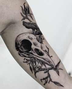 a black and white photo of a bird's skull with flowers on its head