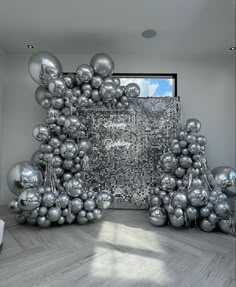 a bunch of balloons that are in front of a wall with a mirror on it