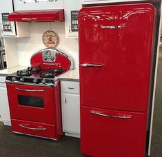 an old fashioned red refrigerator and stove in a store