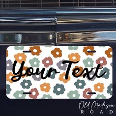 a license plate that says, your text on it with flowers and leaves in the background