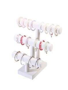 an assortment of rings and earring holders on a white stand