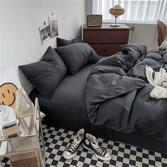 an unmade bed in a bedroom with black and white checkered flooring