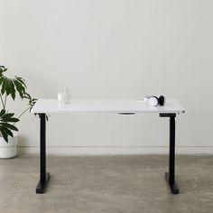 a white table sitting next to a potted plant