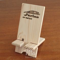 a wooden phone holder with a boat on it's back and the words, surfboards for merchant