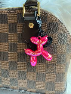 a brown and black purse with a pink flower on it