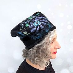 "This Nunofelted Beanie Cap in Black Merino Wool is a stylish and practical accessory that is good for any occasion. Its playful design features a cheeky tip that angles to one side, adding a touch of whimsey to your look. The hat is wet felted from high-quality Merino wool roving, making it lightweight and easy to wear.  The stained glass pattern on the beanie is inspired by the iconic floral motifs of Harry Clarke, giving it a unique and artistic appeal. Whether you are exploring the seaside or simply adding a punctuation mark to your urban street style, this Nunofelted beanie is a versatile and warm accessory that you will love to wear. And if travelling, it's packable - just fold it up and put it in your purse or rucksack. COLOUR: * This felted hat is primarily black felted wool with c Recycled Wool Sweater Hat Felted, Handmade Black Felt Hat For Winter, Harry Clarke, Felted Hat, Stained Glass Pattern, Wool Roving, Wet Felt, Silk Fabrics, Glass Pattern