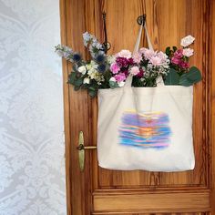 a tote bag with flowers in it hanging on a door