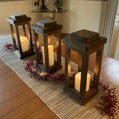 three lit candles sitting on top of a wooden table