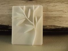 a soap bar sitting on top of a wooden table next to a piece of wood