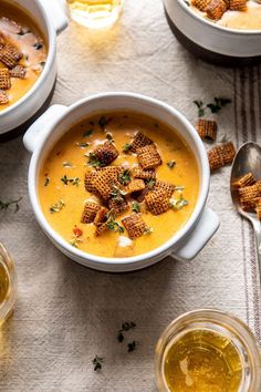 two bowls of soup with crackers on top