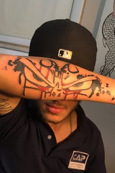 a man with tattoos on his arm covering his eyes