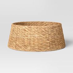 a large round basket that is made out of wicker and sits on a white surface