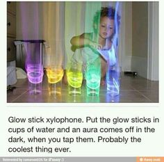 a girl is playing with colored cups on the floor and text reads glow stick xylphone put the glow sticks in cups of water and an aura comes off in the dark, when you tap them