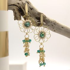 EMMA Earrings These elegant and bohemian long flower earrings are adorned with dazzling green and cream crystals wrapped in golden copper wire. They're perfect for adding a sophisticated contrast and a touch of sparkle and elegance to any outfit. Crafted from high-quality materials, they're ideal for special occasions or for adding a bit of glamour to your everyday look. The length of the earrings adds sophistication, while the crystals catch the light beautifully. Perfect for weddings, parties, Bohemian Dangle Flower Earrings For Pierced Ears, Handmade Bohemian Dangle Flower Earrings, Bohemian Flower Drop Earrings With Dangling Beads, Bohemian Flower Earrings With Dangling Beads, Bohemian Green Earrings With Dangling Charms, Green Bohemian Earrings With Dangling Charms, Bohemian Gold Beaded Flower Earrings, Bohemian Green Flower Earrings With Dangling Beads, Bohemian Wire Wrapped Flower Earrings