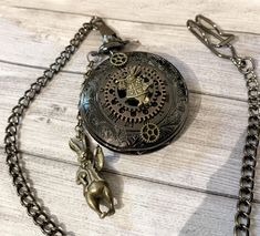 Alice in Wonderland in steampunk gothic fashion with this functional pocket watch. Deliciously crafted accessories, cogs, bronze tone rabbit, trumpet, a chain with the superb White Rabbit in relief on both sides. Ideal gift for Alice Fans. To wear as a necklace chain or with a pocket chain, your choice. With a beautiful diameter of 45 mm.. chain length 80cm. metal tone bronze. The casing opens with a simple pressure, quarter operation, battery already present in the watch and a battery offered i Victorian Skeleton Dial Pocket Watch As Gift, Steampunk Bronze Pocket Watch Gift, Steampunk Bronze Pocket Watch With Locket, Bronze Steampunk Pocket Watch With Locket, Steampunk Metal Pocket Watch As A Gift, Dark Academia Bag, Steampunk Pocket Watch, Pocket Chain, Steampunk Accessories