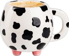 a white and black spotted mug with pink legs