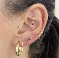 a close up of a person's ear with three different types of piercings