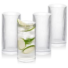 three clear glass tumblers with lime slices in them