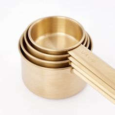 four gold measuring cups stacked on top of each other