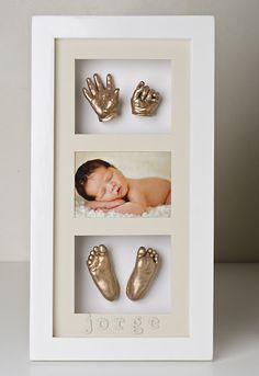 a baby's hand and foot prints in a white frame with gold foil on the feet