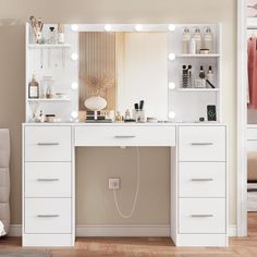 a white vanity with lights on it in front of a mirror and shelves filled with cosmetics