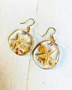 Elegant Organically handcrafted Real starfish and shell fragment earrings encapsulated in high quality resin. Individually handcrafted and super lightweight. Made to order. Gold and warm colored shell fragments or Silver with gray cool tone shell fragment earring options. Makes a beautiful gift for ocean lovers. Take a piece of the ocean with you wherever you go. Pay shipping on 1st pair only and add up to 5 pairs total per package shipped free. White Starfish Shell Gift, Starfish Charm Earrings Gift, Starfish Charm Earrings For Gift, Gift Starfish Charm Earrings, Unique Shell-shaped Earrings For Gift, Starfish Charm Drop Earrings For The Beach, Handmade Shell Starfish Jewelry, Handmade Starfish Shell Jewelry, Shell Dangle Jewelry Gift