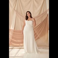 a woman in a white dress posing for the camera