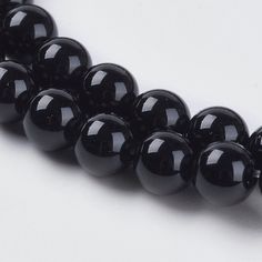 black beads are arranged on a white surface