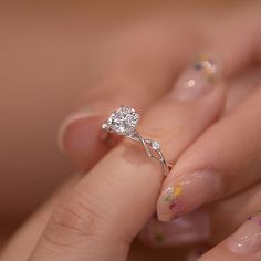 a close up of a person's hand with a ring on their finger and nails