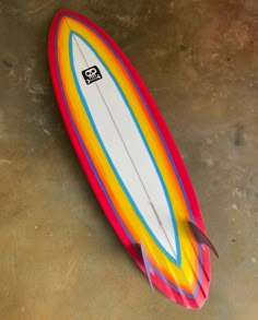 a colorful surfboard laying on the ground