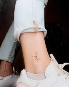 a woman's foot with a small tattoo on her left ankle and lower leg