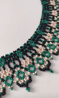 the beaded necklace is green, white and black