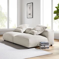 a white couch sitting on top of a wooden floor next to a book shelf in a living room