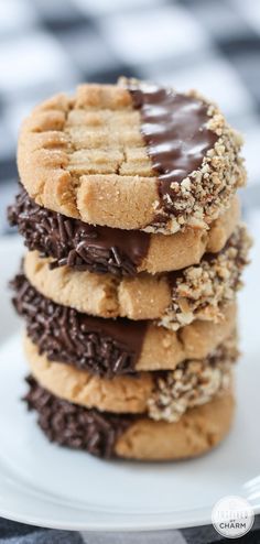 a stack of cookies with chocolate frosting and sprinkles on a white plate